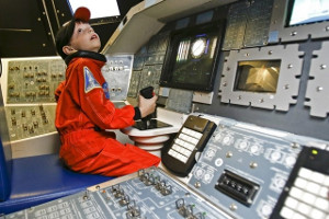 Budding astronaut training on space capusule simulator in the Sally Ride Space Science Exploratorium